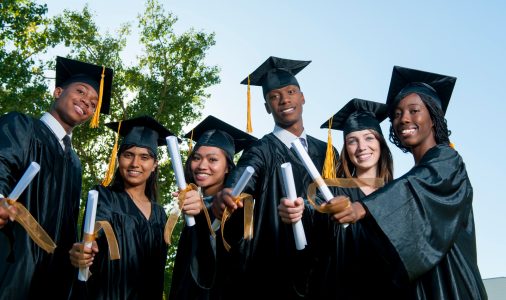 Diverse group of graduates wearing gowns.